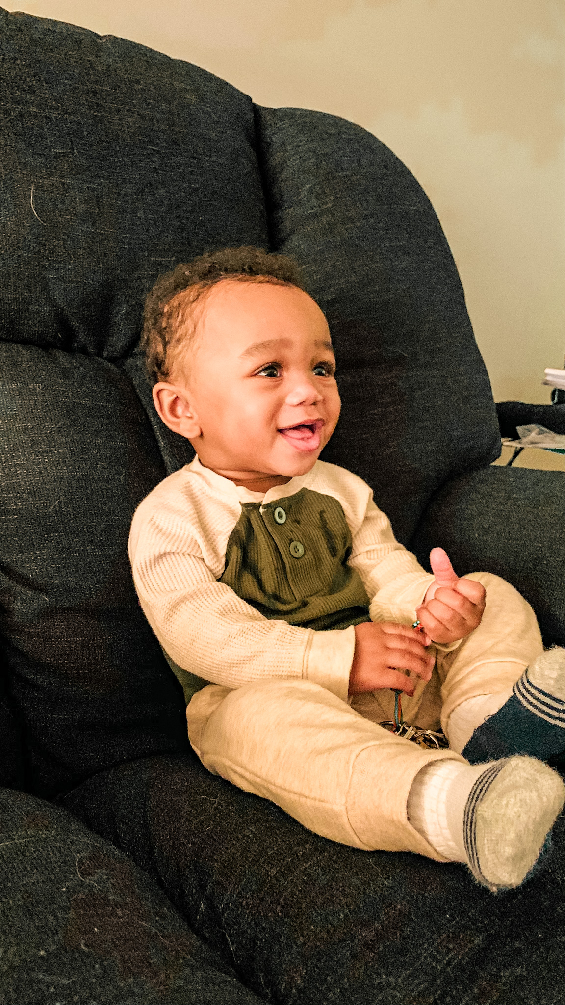 9 monthold baby black boy, laughing with family and he is enjoying his time with others. 